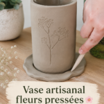 Vase en céramique décoré avec des fleurs pressées, présent dans une ambiance chaleureuse.